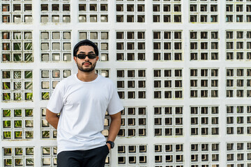 A young bearded handsome man doing a pose while wearing his white blank shirt