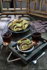 Marble cake served with tea on a wooden tray