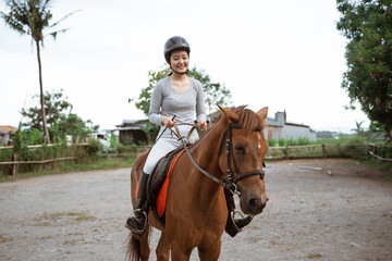 beautiful woman equestrian athlete practicing horse riding on outdoor background