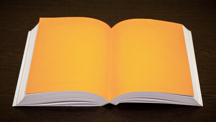 An open book with orange pages on a dark wooden background