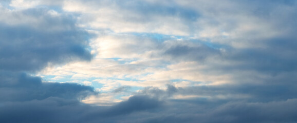 The sky with dark blue and light, illuminated by the evening sun, clouds