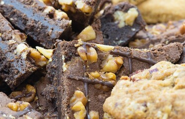 Cookies and chocolate brownies topped with walnuts piled on a serving platter. Homemade baked...