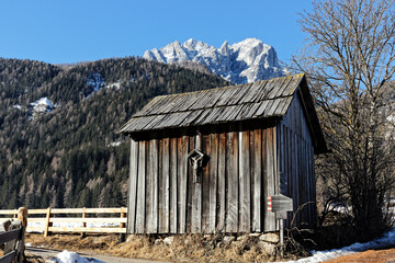 Wooden hut and the snow covered mountain peaks of the Sesto Dolomites in Winter. Alps, South Tyrol, Alto Adige, Italy, Europe