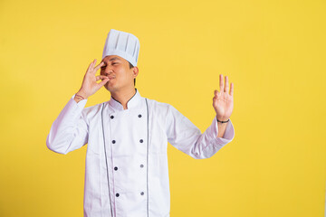 male chef wearing chef jacket with okay hand gesture while tasting delicious food on isolated background