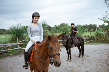 two equestrian athletes ride horses and start training in outdoor background