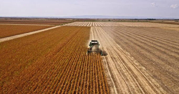 A bird's eye view of a combine harvester at work on a sustainable soybean farm
