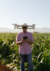 Drone represents the head and eye of an engineer. Drone focused on the foreground and farmer behind him with the drone between his head and the camera. Concept technology in the field, 