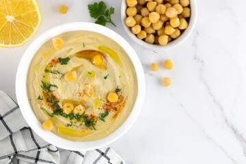 Hummus with chickpeas, parsley and olive oil on a white background, top view. Arabic and Turkish cuisine.