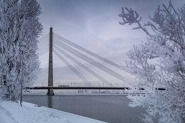 Walking path overlooking the cable-stayed bridge which crosses the Daugava river in Riga, Latvia. Winter cityscapes.