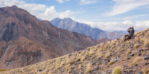 Mountain landscape with huntsman in camouflage who watches through binoculars.