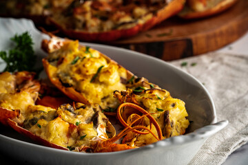 Lobster thermidor, a classic lobster dish in which a cooked lobster is halved down middle. The meat...