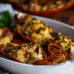 Lobster thermidor, a classic lobster dish in which a cooked lobster is halved down middle. The meat...
