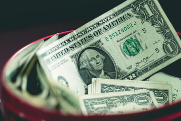 Uma caixa de dinheiro cheia de notas de hum dólar dos Estados Unidos. Guardar dinheiro,...