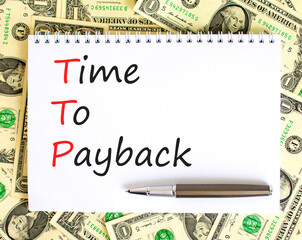 TTP time to payback symbol. Concept words TTP time to payback on white note on a beautiful background from dollar bills. Business TTP time to payback concept. Copy space.