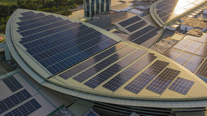 Aerial view of a solar panel photovoltaic with reflection on building roof top.