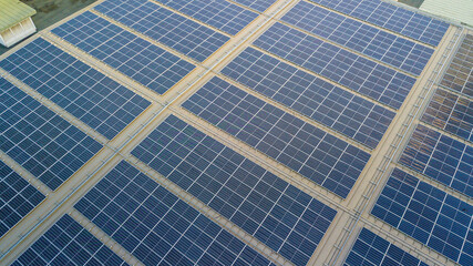 Fototapeta premium Aerial view of a solar panel photovoltaic with reflection on building roof top.
