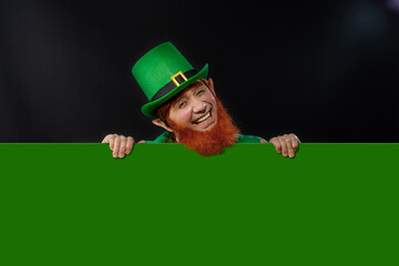 Leprechaun elf on St. Patrick's Day. Cheerful character Irish leprechaun for advertising with a red...