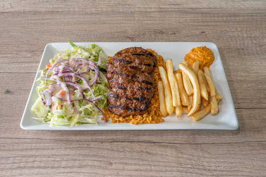 Paris, France - 12 07 2022: Middle East dishe culinary Still Life. Kofta plate with french fries, wheat and salad