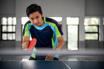 close up of a male ping pong player in a position ready to compete in a ping pong match