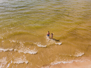 Aerial drone shot of two people going in to sea