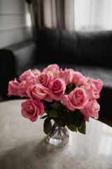 Pink roses on grey granite table with dark background