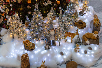 A lot of toys , rabbit, deers and fox, Santa Cloth standing under the Christmas tree.