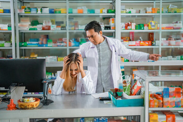 Asian male pharmacist angry at female pharmacist for mishandling customers at the pharmacy