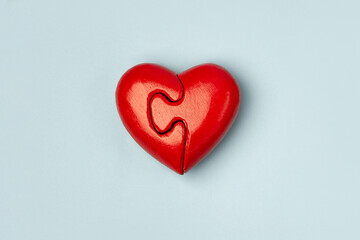 Red heart of two folded halves  on a blue background with copy space . Psychology and Valentine day  concept .