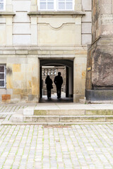 Sillouette of a couple walking through archway at Christiansborg Palace, Copenhagen, Denmark