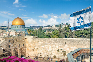 An Israeli flag blows by the Western Wall and dome of the rock in Old City in Jerusalem, Israel.	