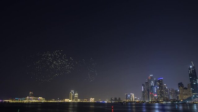 Time lapse of drone show between Jumeirah beach and blue water al ain wheel at night.