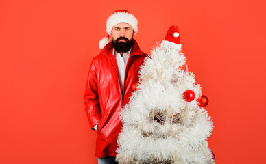 Winter holidays. Bearded businessman in Santa hat with Christmas tree. Happy New Year.