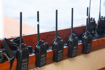 Lots of walkie-talkies attached on the windowsill, close-up. - obrazy, fototapety, plakaty