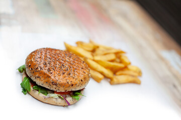 Tasty, fresh hamburger with french fries on a white table unhealthy food