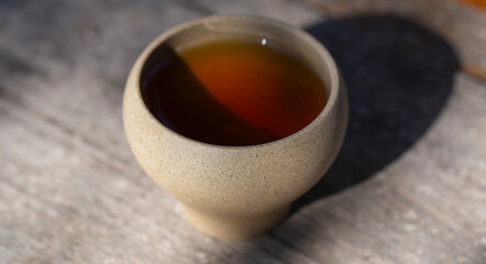 Obraz na płótnie Canvas White terracotta cup with oolong tea close-up.