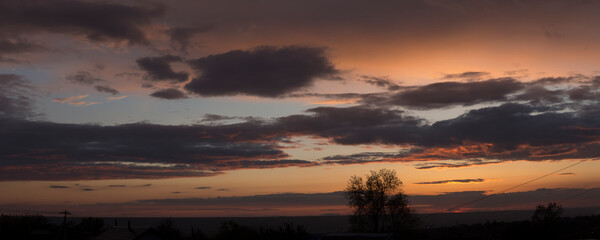 Landscape at sunset. Tragic gloomy sky. Panorama. Crimson twilight.