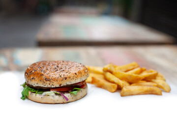 Tasty, fresh hamburger with french fries on a white table unhealthy food