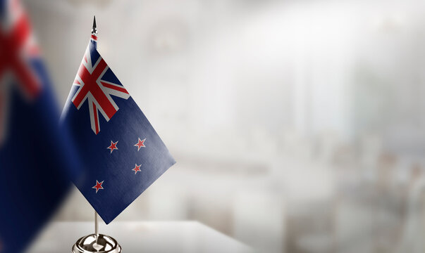 Small flags of the New Zealand on an abstract blurry background