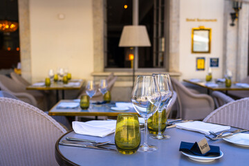Glasses and cutlery on tables outside of a restaurant