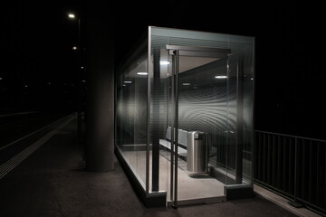Illuminated waiting room at night in Switzerland. Glass waiting room,  Swiss Train station