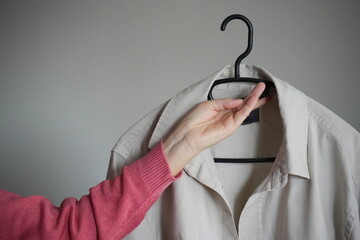 Woman holding shirt after ironing 