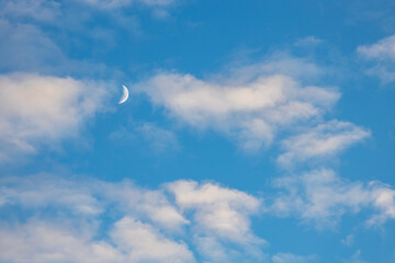 Moon on blue sky with clouds