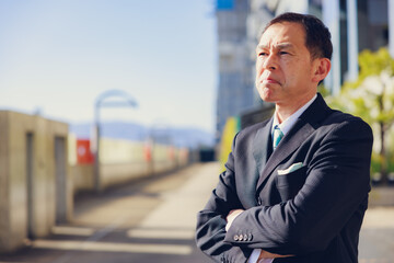 Fototapeta premium Middle-aged Asian man in black business suit at Kyoto station building, Japan.
