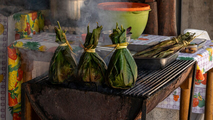 typical food of the jungle. charcoal grilled meat inside banana leaves