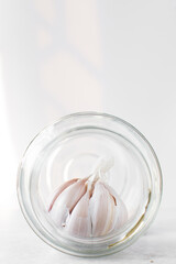 Fototapeta na wymiar Garlic bulb in a glass jar, unpeeled garlic , raw garlic, Allium sativum