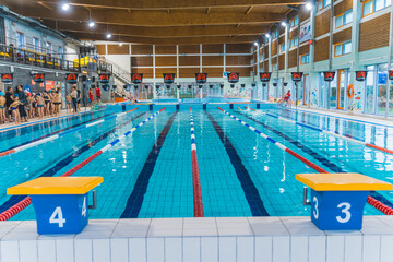 Indoor public swimming pool. Platforms for diving. No people swimming. High quality photo