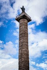 From below of famous Marcus Aurelius Column located in center of Rome on cloudy day