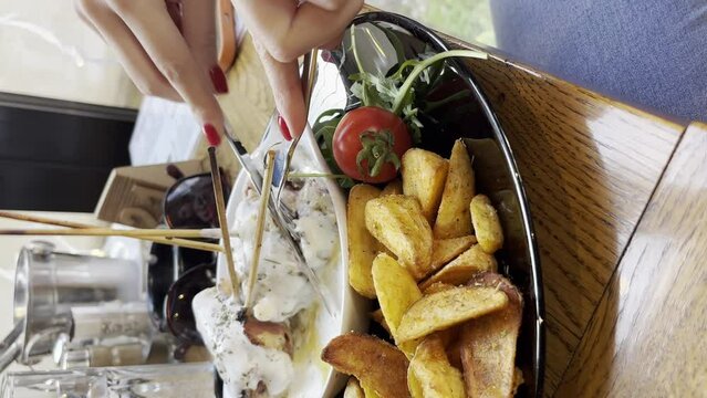 Close up on hand of unknown person eat potato chips and gorgonzola cheese meat from plate at restaurant UGC user generated content vertical video