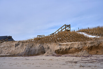 a damaged shoreline and broken stairs leading to the beach in the Hamptons