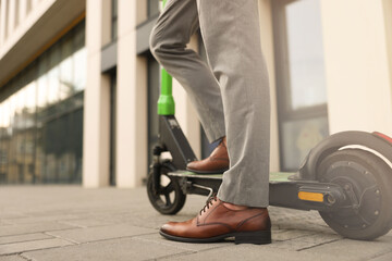 Obraz premium Businessman with modern kick scooter on city street, closeup. Space for text
